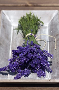 Freshly harvested lavender tied together with thread in a wooden bowl