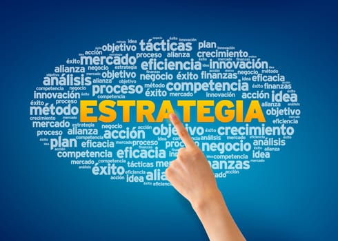 Hand pointing at a Estrategia Word Cloud on blue background.