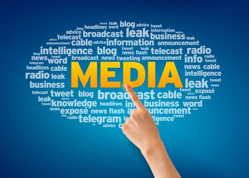 Hand pointing at a Media Word Cloud on blue background.
