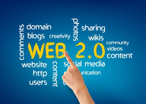 Hand pointing at a Web 2.0 word illustration on blue background.