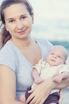 Young mother with baby on the beach