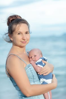 Young mother with baby on the beach