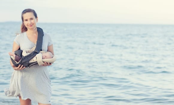 Young mother with baby on the beach