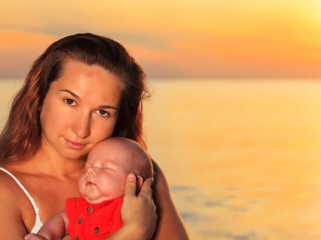 Mother and baby on the beach at sunrise