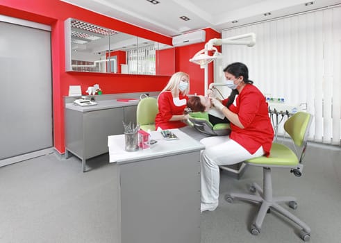 Dentist and nurse at work in modern dental office