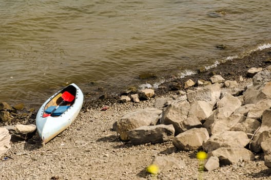 Canoe sitting next to the shore of the Willamette River in Portland, Oregon