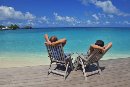 happy young couple have fun and relax at summer vacation on background maldives travel location and beautiful white sand beach