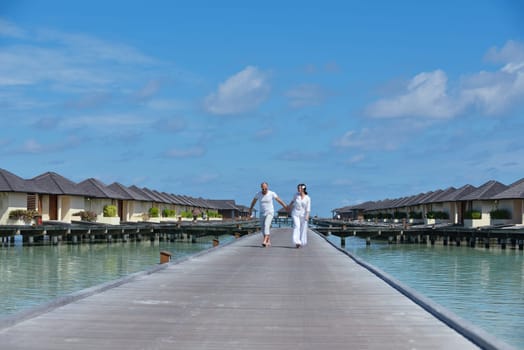 happy young couple have fun and relax at summer vacation on background maldives travel location and beautiful white sand beach
