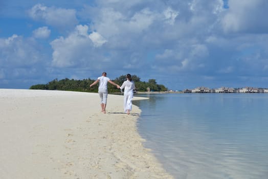 happy young couple have fun and relax at summer vacation on background maldives travel location and beautiful white sand beach