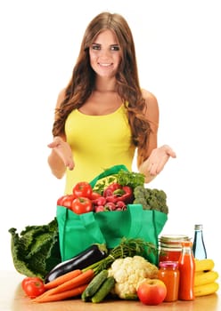 Young woman with variety of grocery products in shopping bag isolated on white