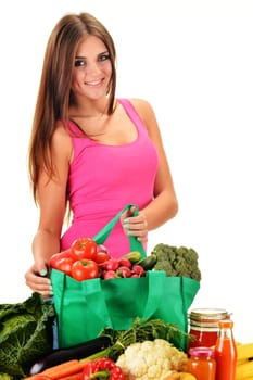 Young woman with variety of grocery products in shopping bag isolated on white