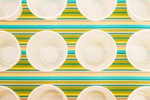 Lots of disposable cups on a colorful background.