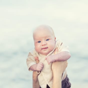 Human hands are holding adorable baby