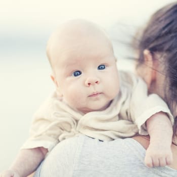 Young mother with baby on the beach