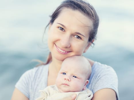 Young mother with baby on the beach