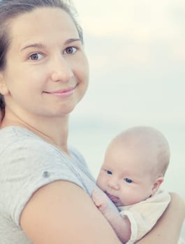 Young mother with baby on the beach