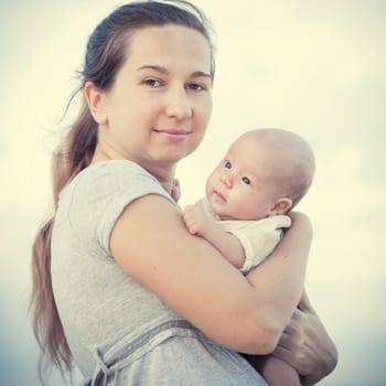 Young mother with baby on the beach