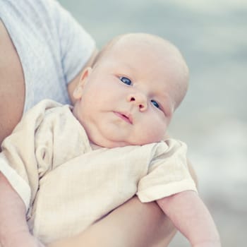 Human hands are holding adorable baby