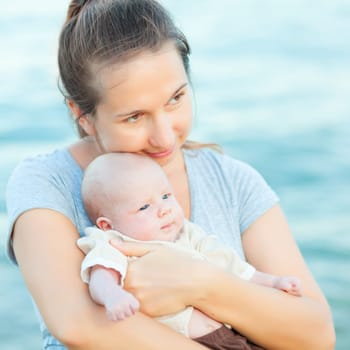 Young mother with baby on the beach