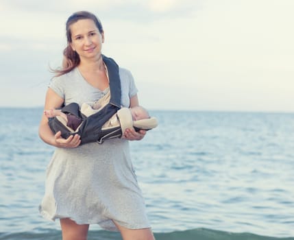Young mother with baby on the beach