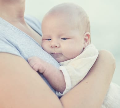Young mother with baby on the beach