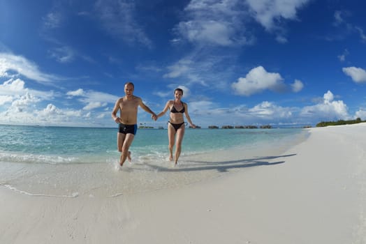 happy young couple have fun and relax at summer vacation on background maldives travel location and beautiful white sand beach