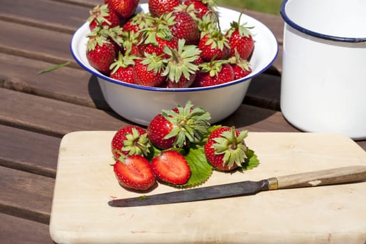 Strawberries,freshly harvested on a cutting board with a knife