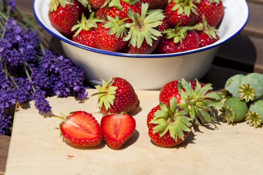 Freshly harvested strawberries,lavender bunches and poppy seed capsules in summer