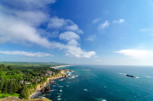 Lush green Oregon coast with blue sky and Pacific Ocean