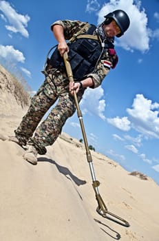 iraqi soldier in the desert with army metal detector