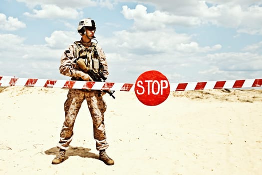 US marine with assault rifle near the barrier at a checkpoint