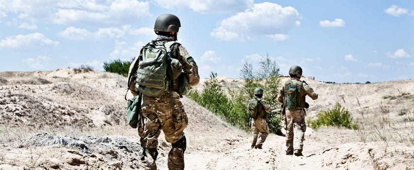 Squad of soldiers patrolling across the desert