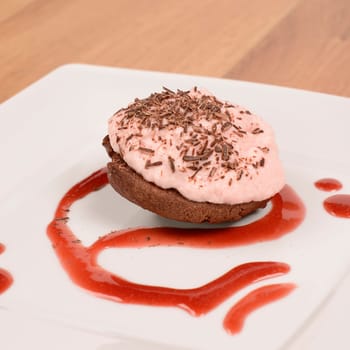 Sweet cake with strawberry cream and chocolate on a plate