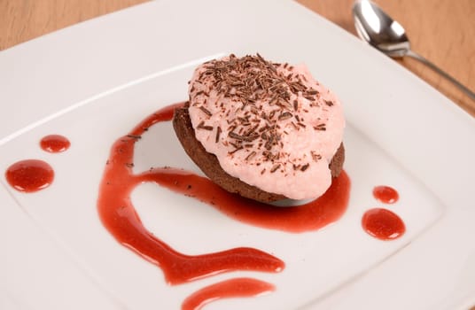 Sweet cake with strawberry cream and chocolate on a plate