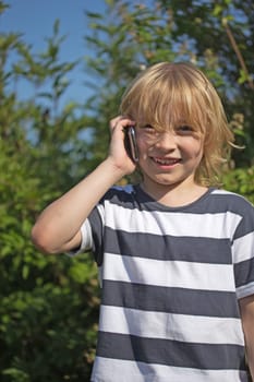 Attractive blond boy is calling and laughing outdoors