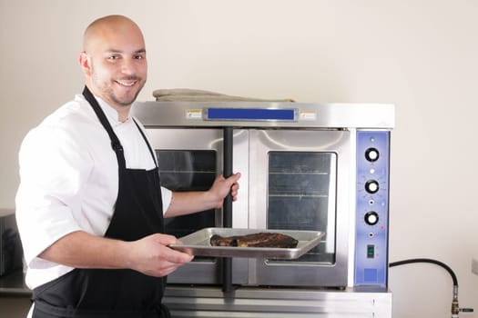 Happy chef taking his freshly baked rib-eye steak