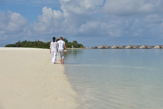 happy young couple have fun and relax at summer vacation on background maldives travel location and beautiful white sand beach