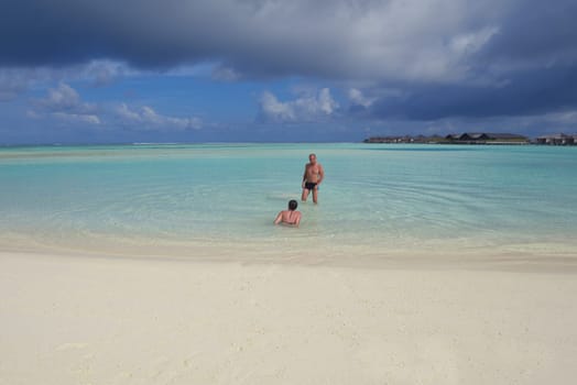 happy young couple have fun and relax at summer vacation on background maldives travel location and beautiful white sand beach