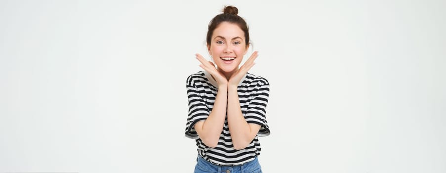 Portrait of beautiful, excited brunette woman, feeling excited and upbeat, smiling and looking happy, standing over white background.