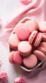 A bowl of pink macarons on a pink background