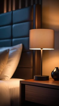 A lamp is on a nightstand in front of a bed
