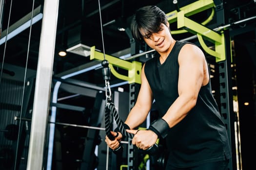 Bodybuilder doing cable pulldowns to work on his triceps and build a muscular and powerful upper body, using a cable machine at the fitness center. Upper body strength exercise