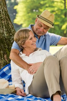 Happy elderly wife and husband hugging in park