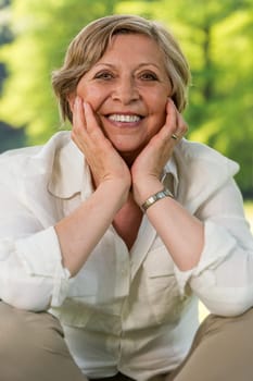 Smiling elderly woman looking at camera outdoors