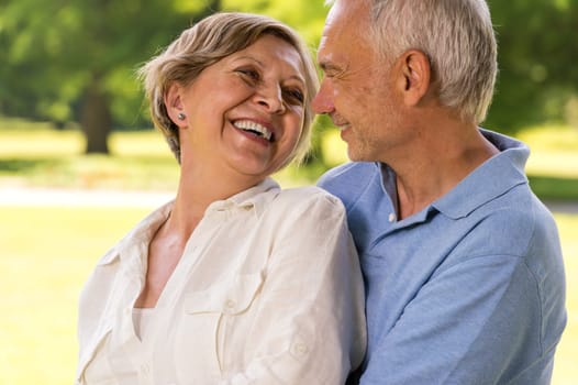 Happy retirement senior couple hugging and smiling at each other