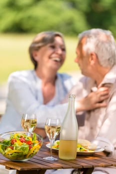 Happy senior wife and husband dining outdoors