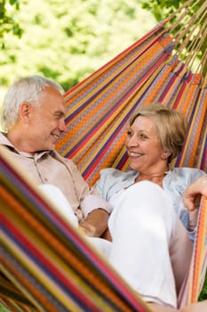 Happy elderly couple lying in hammock