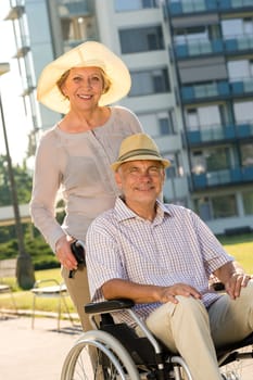 Wealthy senior man in wheelchair with wife retirement