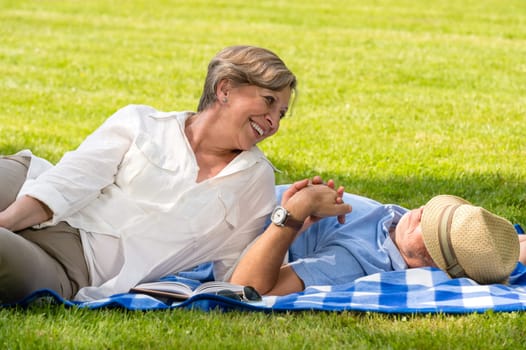 Elderly couple enjoying relax time in sunny park