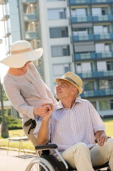 Senior wife with disabled husband on wheelchair wealthy retirement